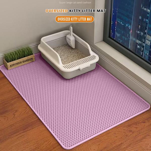 Oversized pink kitty litter mat with textured surface under cat litter box near window